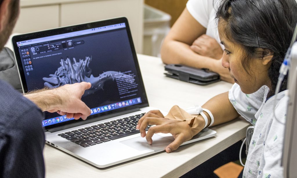cropped pic 2 A Teaching Artist uses digital design software with a female hospital patient